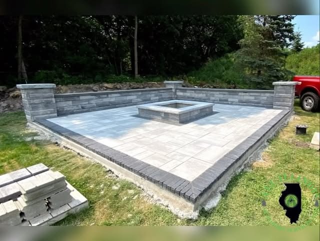 Paver patio with a square fire pit and seating wall